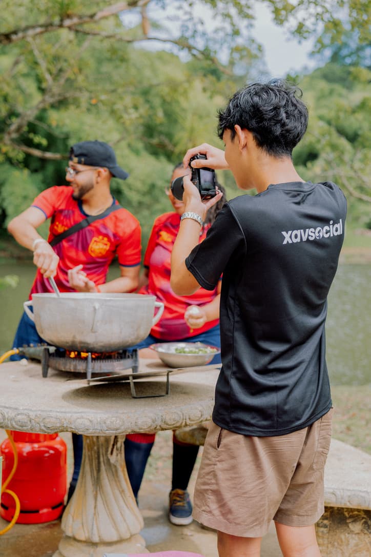 A photographer filming an outdoor cookout