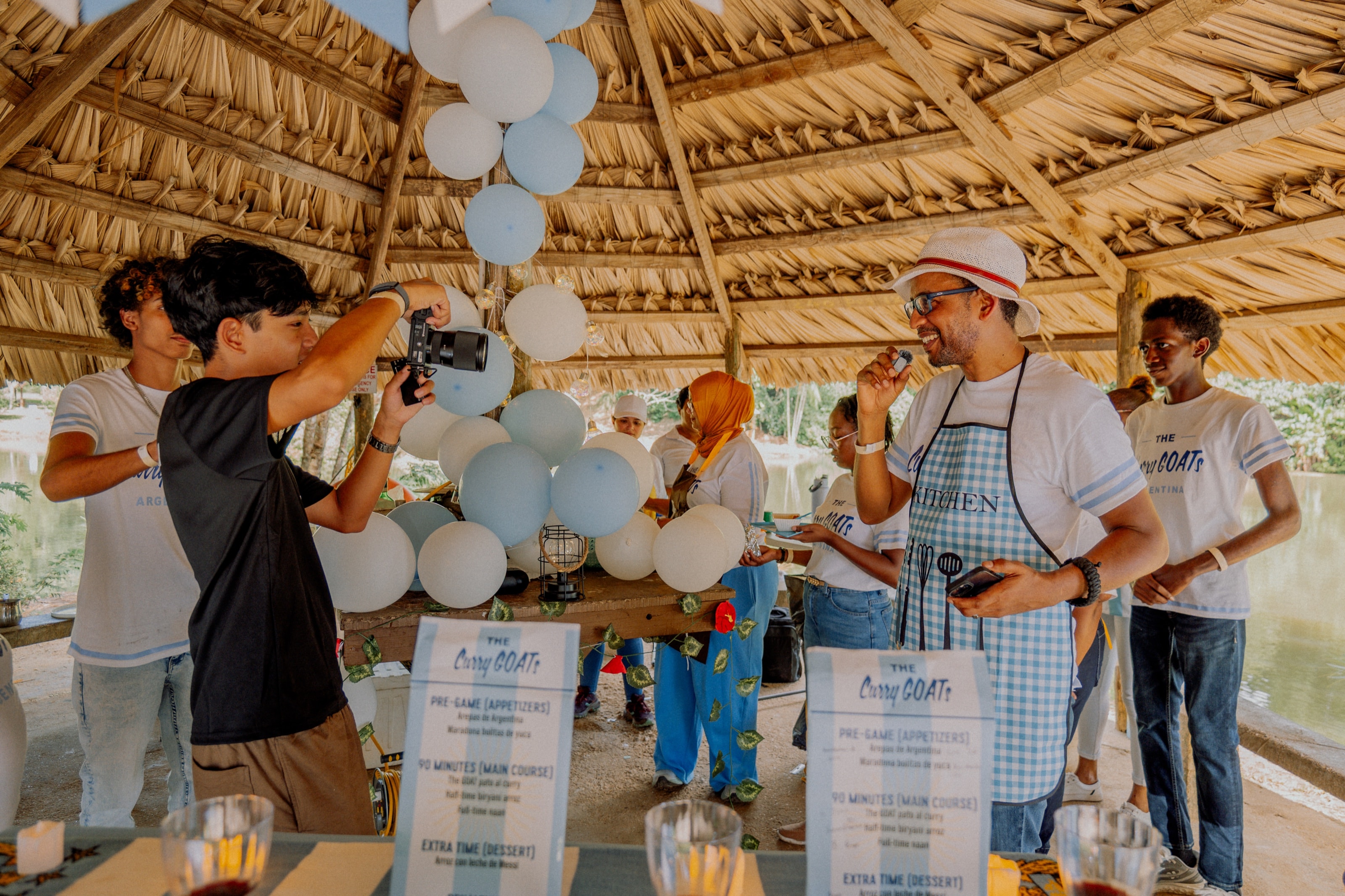 A videographer filming an outdoor cooking event