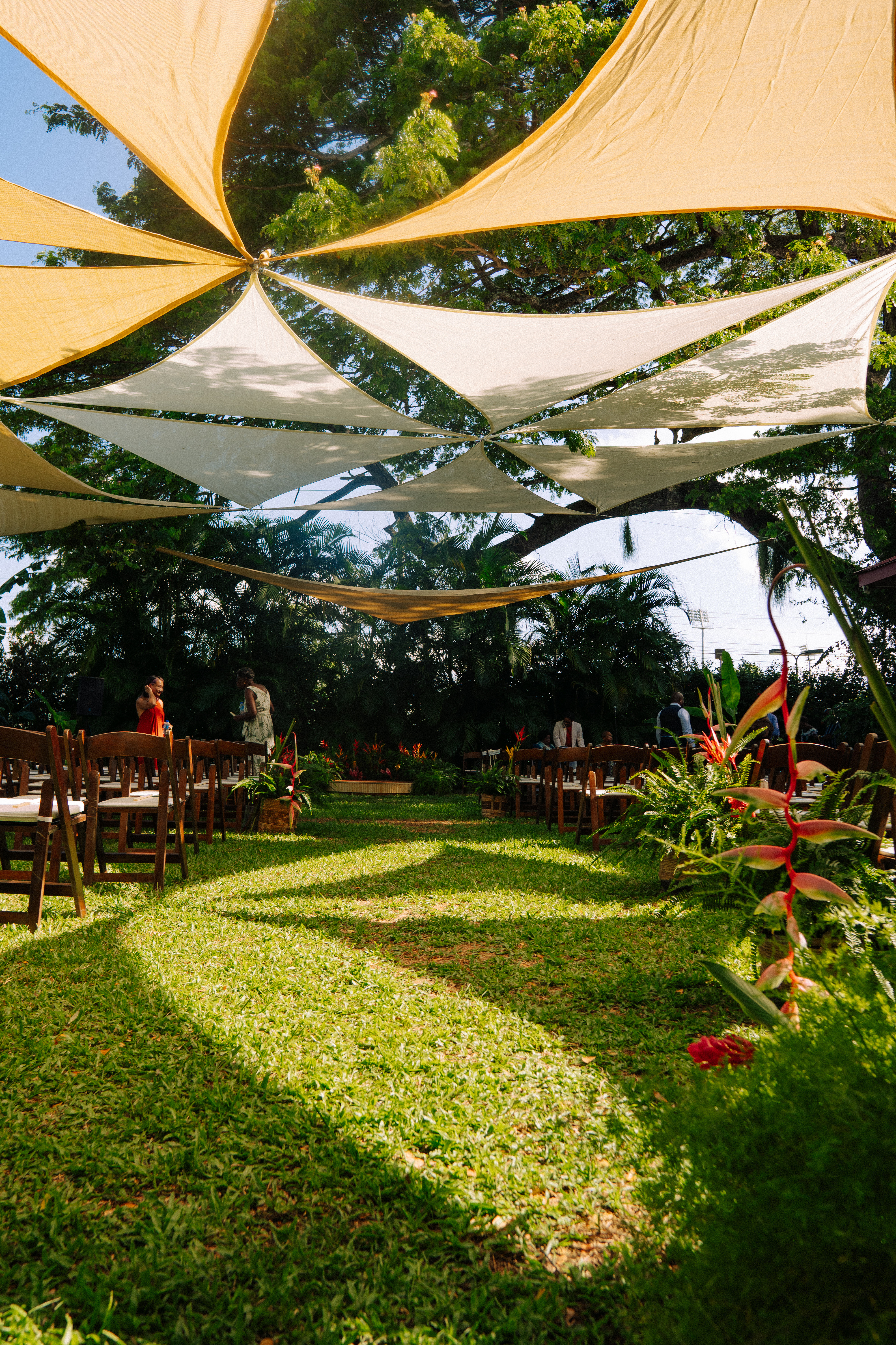 The outdoor ceremony aisle beneath cream and gold shade sails