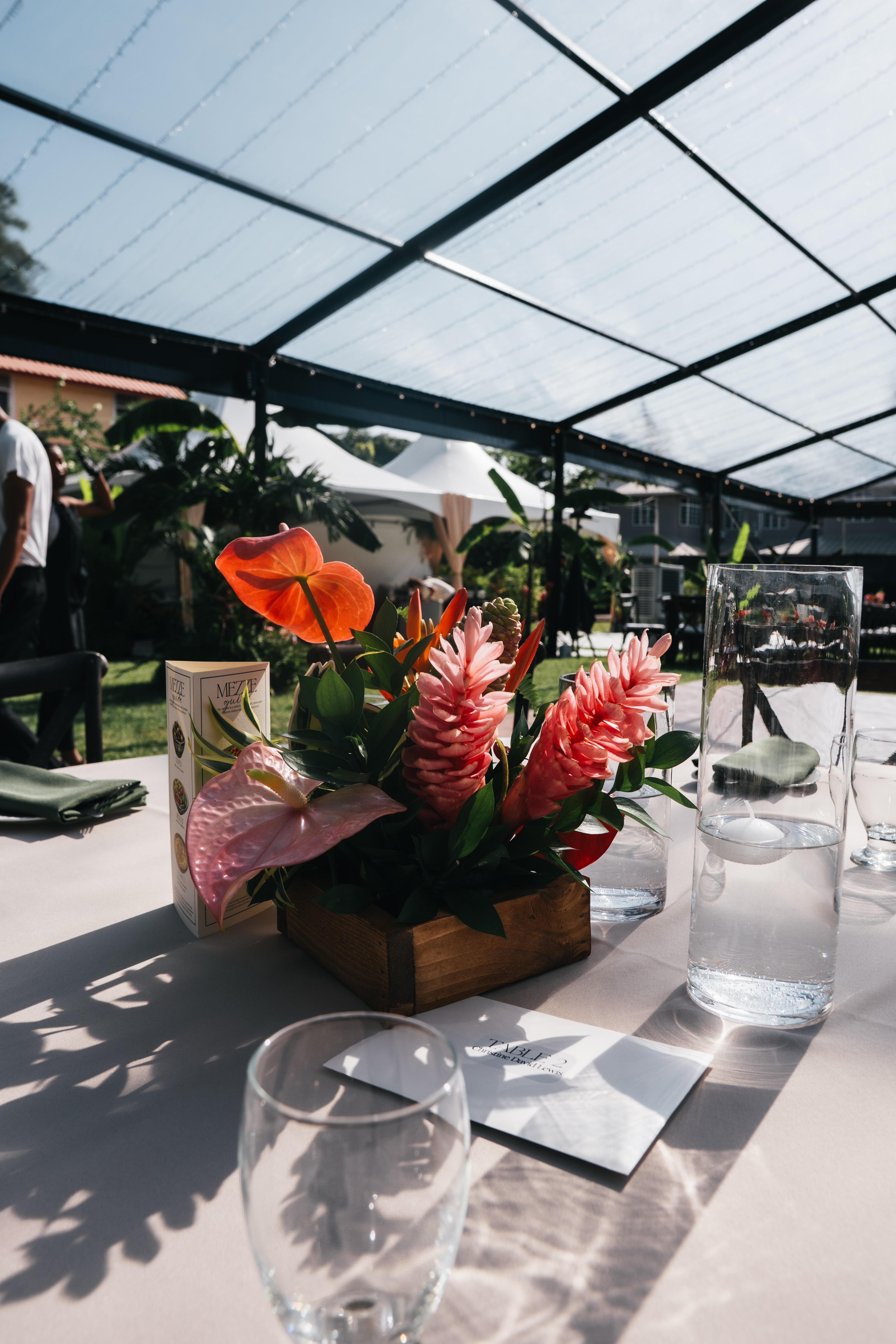 A tropical flower arrangement on a sunlit reception table