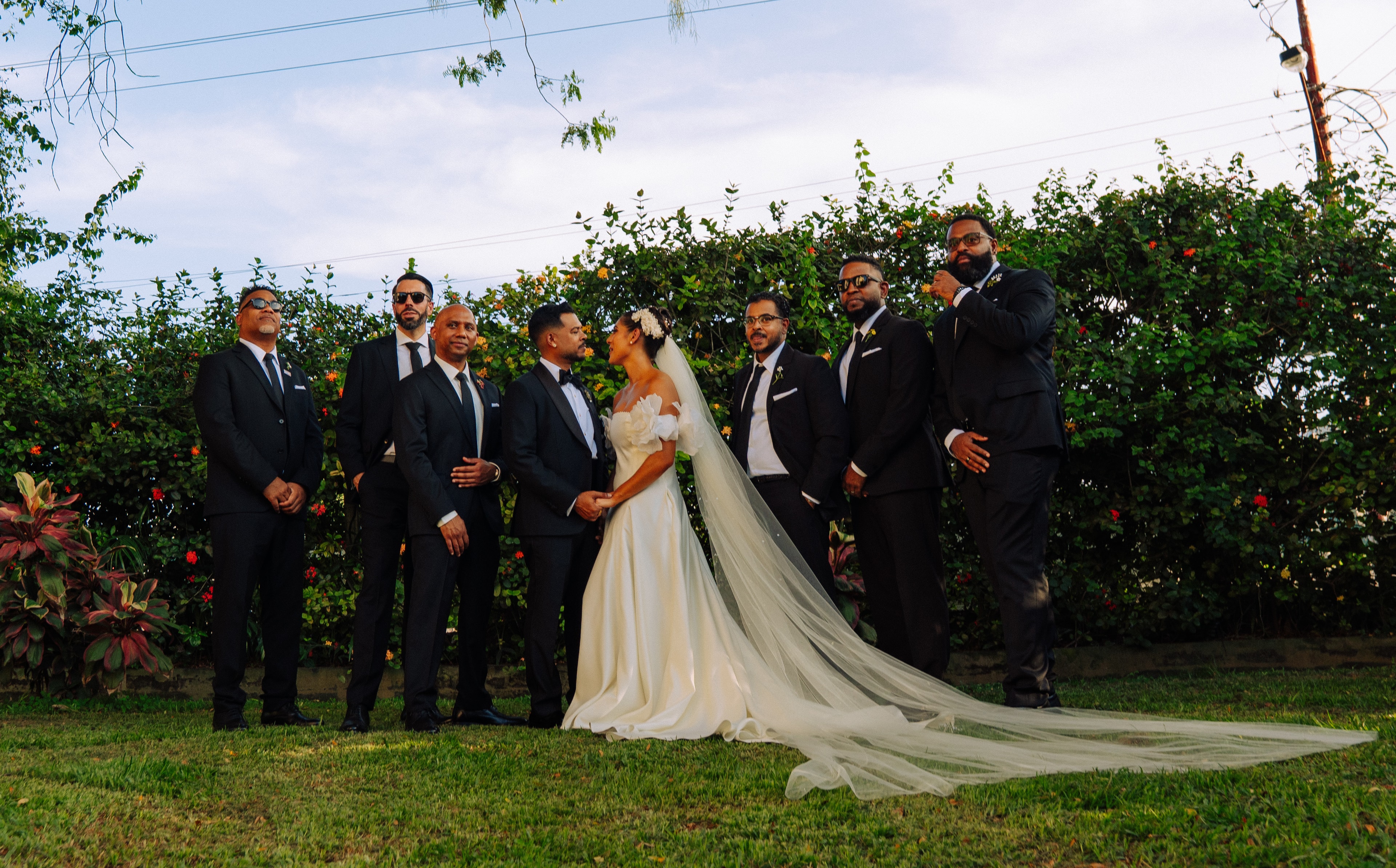 Kevin and Alix facing each other with the groomsmen beside them