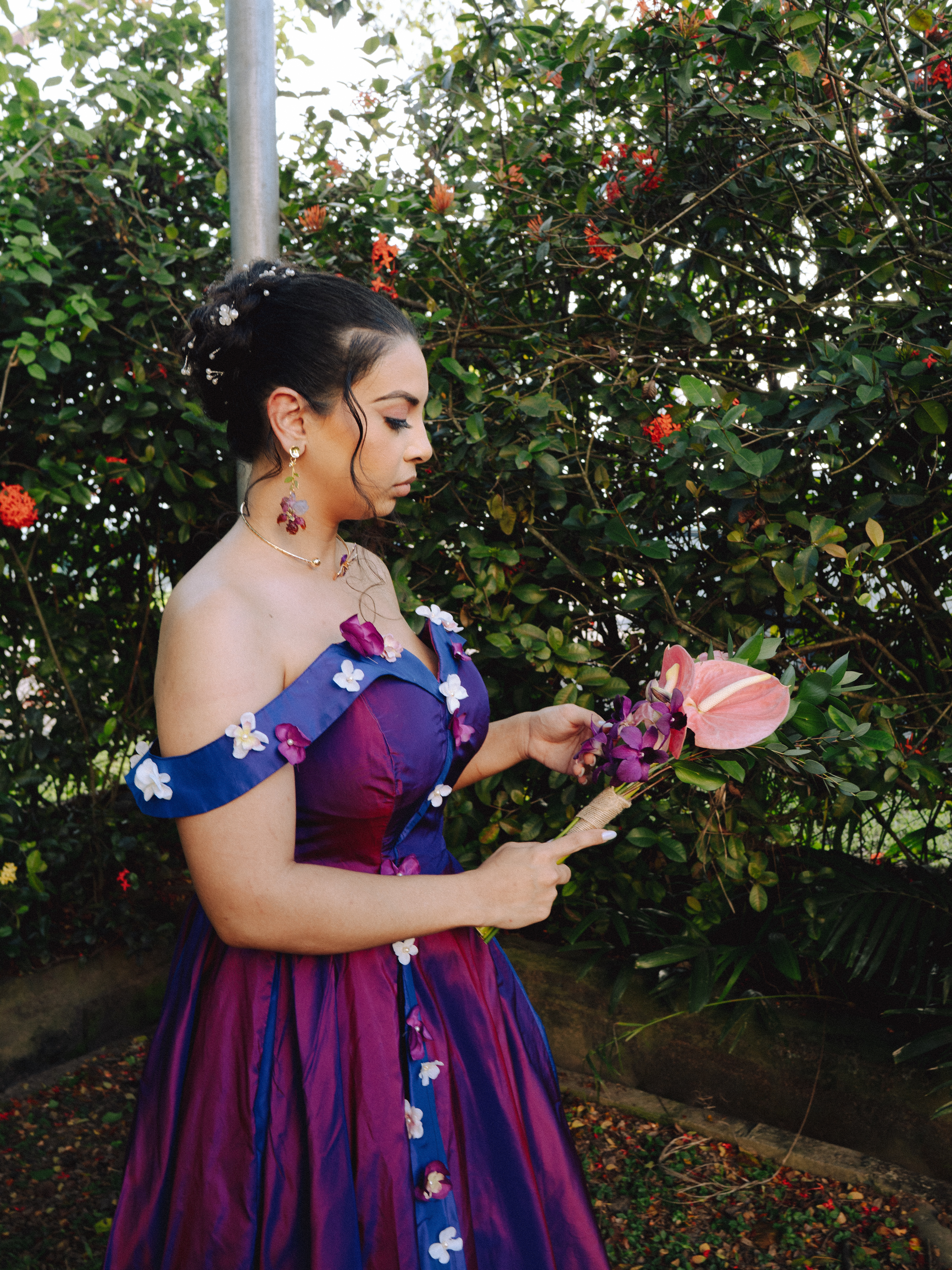 A bridesmaid looking down at her tropical bouquet