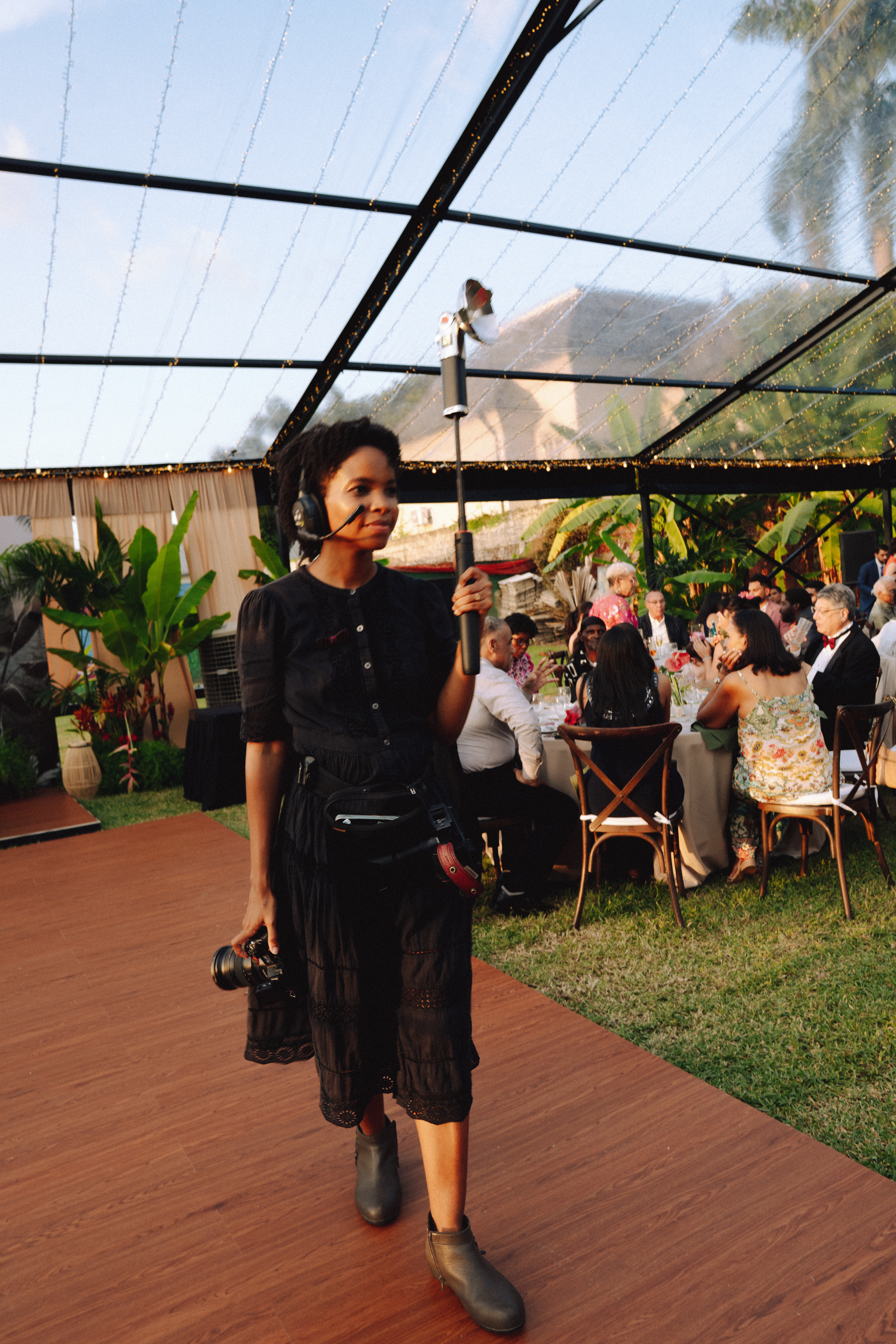 A wedding photographer carrying a camera and light at the reception